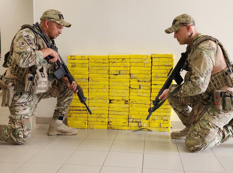 Agentes da PRF ao lado da droga apreendida - Foto PRF