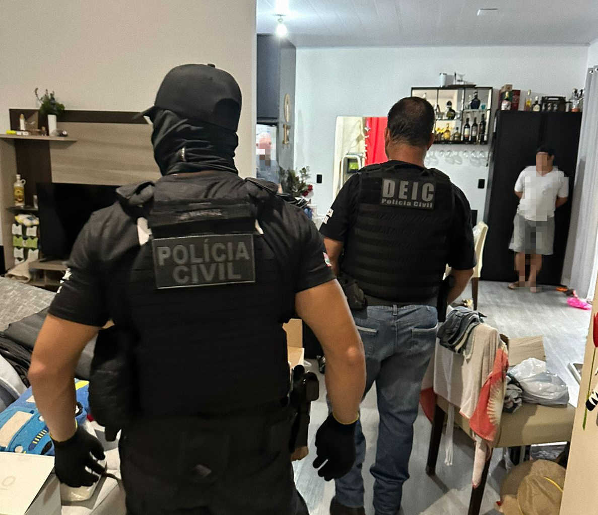 Policias na casa onde integrante da quadrilha foi encontrado - PCSC